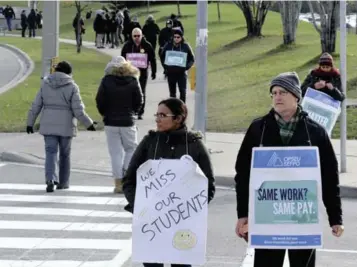  ?? METROLAND ?? Striking Humber College faculty members walk the picket line outside the school’s north campus last week.