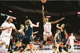  ?? JULIA NIKHINSON/AP ?? Maryland guard Diamond Miller reaches for the ball during the second half of Thursday night’s win over Michigan in College Park.