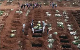  ?? ANDRE PENNER — THE ASSOCIATED PRESS FILE ?? Cemetery workers lower the coffin of a person who died from complicati­ons related to COVID-19into a grave at the Vila Formosa cemetery in Sao Paulo, Brazil.