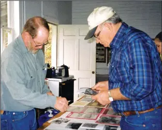  ?? Photo courtesy Shiloh Museum ?? Wayne Martin (left) shares historic photos at Pettigrew Day in April 2004. For over 20 years, the museum cosponsore­d the annual Pettigrew Day, along with community leaders like Wayne and June Martin. The event honored, collected and preserved the rich history of Pettigrew and south Madison County.