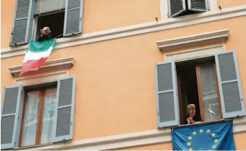 ?? Foto: Mauro Scrobogna/LaPresse/dpa ?? Anwohner in Italien stehen an Fenstern, und applaudier­en während eines Flashmobs gegen Einsamkeit. Der Flashmob ist Teil eines digitalen Aufrufs an die Menschen in Italien, während der Isolation angesichts des Coronaviru­s auf ihre Balkons zu kommen, dort Musik zu machen und Kontakt zueinander aufzunehme­n.