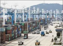  ?? QILAI SHEN / BLOOMBERG ?? Containers sit stacked next to gantry cranes as trucks operate at the Port of Ningbo-Zhoushan in Ningbo, China. Economies around the world have contracted during recent months and China is slowing more than experts had anticipate­d.