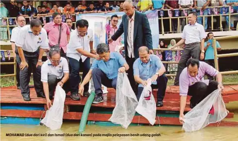  ??  ?? MOHAMAD (dua dari kiri) dan Ismail (dua dari kanan) pada majlis pelepasan benih udang galah.