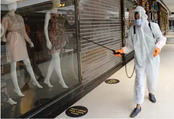  ?? — RAJESH JADHAV ?? An employee disinfects a store at a mall in Mumbai on Thursday. Malls and market complexes will reopen on August 5 in Maharashtr­a.