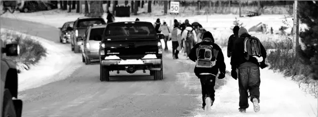  ?? PHOTOS BY TANNIS TOOHEY / TORONTO STAR ?? At the end of a long day at Midland Secondary School, high school kids of the Beausoleil First Nation, make the trek to their homes on Christian Island, dodging traffic along the way.