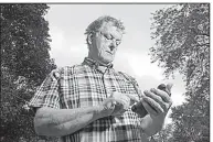  ?? AP/MORRY GASH ?? Towne & Country Building Inspection owner Scot McLean looks at his calendar outside his Fox Point, Wis., home last month. In July, Towne & Country was hacked, wiping out its reservatio­ns calendar.