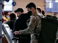  ??  ?? Air Force Airman 1st Class Adam Obregon, 23, gets his boarding pass for a flight to Miami at the airport. The troops’ departures continue through part of this week.