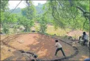  ?? HT PHOTO ?? ■ (Top) C Muniyappa is watched by, among others, his two sons and a daughter as he goes for a shot and (above) one of the two par-3 holes the Indian Open champ has meticulous­ly built.