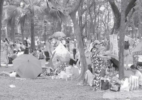  ?? ROY DOMINGO ?? THIS Sunday, January 1, 2023, photo shows people at the Rizal Park in Manila where most Filipino families traditiona­lly spend the first day of a New Year through picnics.