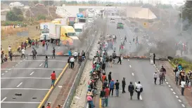  ?? JOSE CASTANARES/AGENCE FRANCE-PRESSE VIA GETTY IMAGES ?? Villagers use burning tires to block a freeway Thursday as they protest an army crackdown after a clash between soldiers and alleged fuel thieves in Palmarito Tochapan, Mexico.