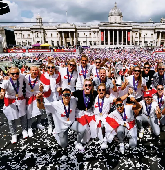  ?? ?? Job done…now it’s party time: England’s Euros heroes pose for a team photo next to their newly acquired trophy during jubilant celebratio­ns in a packed Trafalgar Square