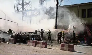  ??  ?? Scene of the crime: Police and firemen working at the site of the attack in Jalalabad. — AP