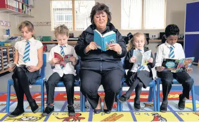  ??  ?? Read up Sharon Wilson reads with some of the Chapelton Primary pupils