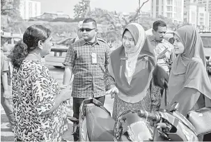 ?? — Gambar Bernama ?? BERAMAH MESRA: Halimah (tengah) beramah mesra bersama penduduk setempat pada kempen PRK DUN Seri Setia di Pasar Tani Taman Medan, Peteling Jaya, semalam.