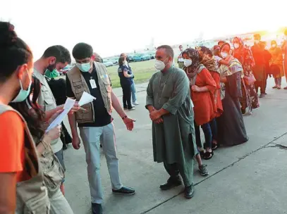  ??  ?? Recién llegados a la base aérea de Torrejón de Ardoz hacen fila para ser atendidos