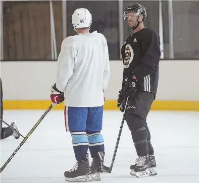  ?? STAFF PHOTO BY PATRICK WHITTEMORE ?? CENTER OF ATTENTION: David Krejci chats with an unidentifi­ed player during Bruins captains’ practice Thursday at Warrior Ice Arena.