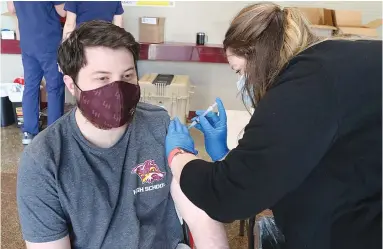  ?? The Sentinel-Record/Richard Rasmussen ?? Q Smith Drug and Compoundin­g employee Courtney Hooker, right, vaccinates Lake Hamilton School District employee Bailey Hughes on Friday.