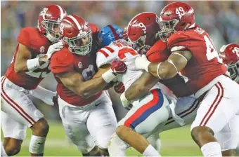  ?? KENT GIDLEY/ALABAMA PHOTOS ?? Alabama defenders, from left, Minkah Fitzpatric­k, Da’Ron Payne, Da’Shawn Hand and Isaiah Buggs don’t leave Ole Miss running back Jordan Wilkins any room to run during last Saturday’s 66-3 Crimson Tide runaway.