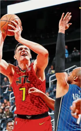  ?? — AFP ?? Going for broke: Ersan Ilyasova (left) of the Atlanta Hawks attempting a shot against Arron Afflalo of the Orlando Magic at Philips Arena on Saturday.