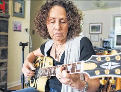  ?? AP PHOTO ?? Frumi Cohen, a guitar teacher in Yardley, Pa., plays in her home. There are multitude of resources for learning to play the guitar, from phone apps and videos to books and teachers.