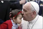  ?? PAULO CUNHA — POOL PHOTO VIA AP ?? Pope Francis kisses a child as he arrives at Monte Real Air Base in Leiria, Portugal, Friday
