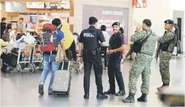  ??  ?? Police and Army personnel patrol at the Penang Internatio­nal Airport. — Bernama photo