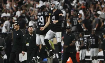  ?? ?? Las Vegas Raiders’ Casey Hayward and Derek Carr celebrate after defeating the Baltimore Ravens during overtime. Photograph: David Becker/AP