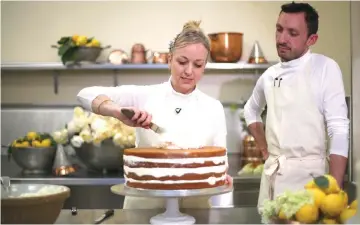  ??  ?? Claire Ptak, owner of Violet Bakery in Hackney, east London, and head baker Izaak Adams put finishing touches to the cake for the wedding of Prince Harry and Meghan Markle in the kitchens at Buckingham Palace in London, on Thursday. (Bottom left) A...