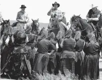  ?? REUTERS ?? Mounted cowboys listen to Hutterites from the Green Acres colony as women members of the colony sing to riders on the side of Highway 56, west of Hussar, Alta.