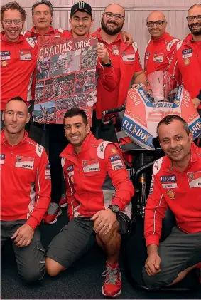  ??  ?? Jorge Lorenzo, 31 anni, 5 volte iridato, posa con gli uomini Ducati mentre tiene tra le mani il poster che gli è stato regalato: in due stagioni in rosso ha vinto 3 corse MILAGRO