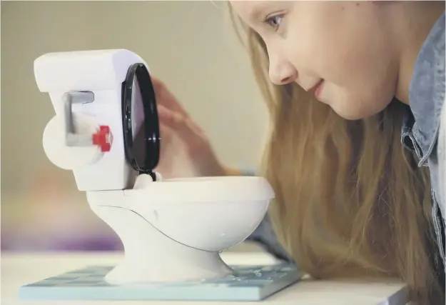  ??  ?? 0 A girl plays with Toilet Trouble, one of the toys to make it on to the festive top 12 list. The toilet is part of a board game
PICTURE: GETTY IMAGES