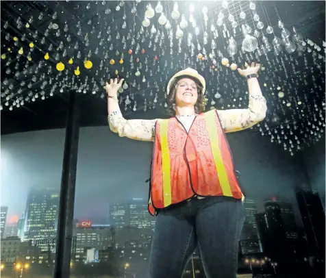  ?? JULIE OLIVER/POSTMEDIA ?? The Canada Science and Technology Museum’s director general, Christina Tessier, marvels at the huge art installati­on being installed made up of 1,867 light bulbs. With four months to their opening on Nov. 17 — 50 years to the day since it first opened...