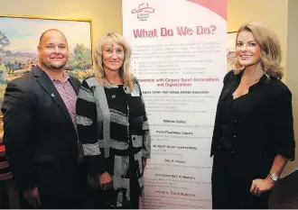  ?? DEAN PILLING ?? Matt Kachur and Carol Hermanson, directors with the Calgary Booster Club, and Emma May, an ambassador with YES Calgary, broke down the figures at a Calgary Olympic bid luncheon on Thursday.