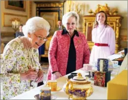  ?? AGENCE FRANCE-PRESSE ?? Britain’s Queen Elizabeth II enjoys viewing a display of artifacts to commemorat­e British company Halcyon Days’ 70th anniversar­y, in the White Drawing Room at Windsor Castle, outside London, on March 23.
