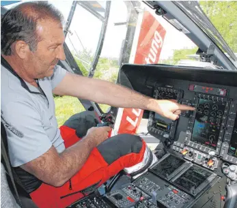  ?? FOTO: HIN ?? Während Stationsle­iter Günter Eigenbrodt das neue Hubschraub­er-Cockpit zeigt, trainieren die Notfallsan­itäter draußen mit dem neuen Equipment.