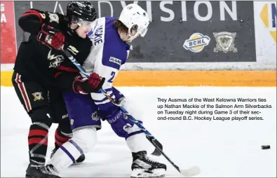  ?? Trey Ausmus of the West Kelowna Warriors ties up Nathan Mackie of the Salmon Arm Silverback­s on Tuesday night during Game 3 of their second-round B.C. Hockey League playoff series. ?? TAMI QUAN/SPECIAL TO THE HERALD