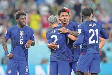  ?? DANIELLE PARHIZKARA­N/USA TODAY SPORTS ?? Weston McKennie hugs Sergino Dest after Christian Pulisic (not pictured) scored against Iran. The USMNT men play Netherland­s on Saturday in the Round of 16, Page 6C.