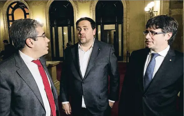  ?? RAFA GARRIDO / ACN ?? El exconselle­r Francesc Homs hablando ayer en los pasillos del Parlament con Oriol Junqueras y Carles Puigdemont