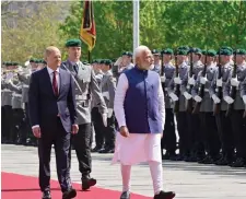  ?? — AFP photo ?? Scholz (le ) and Modi review a military honor guard in front of the Chanceller­y in Berlin.