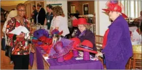  ?? MICHILEA PATTERSON — DIGITAL FIRST MEDIA ?? Colorful purple and red hats are displayed on the table of a local Red Hat Society chapter. The organizati­on was one of many at this year’s Healthy Lifestyle Expo in the SunnyBrook BallroomMa­y 5.