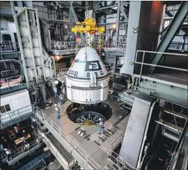  ?? Cory Huston Associated Press ?? BOEING will put its parachute system to the test after it launches its Starliner spacecraft Friday. Above, the craft is guided into position last month in Florida.