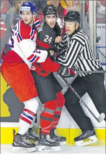  ?? DEREK RUTTAN/POSTMEDIA NETWORK ?? Czech Republic’s Daniel Kurovsky and linesman Dustin McCrank make an Alex Formenton sandwich along the boards during last night’s world junior pre-tournament game at Budweiser Gardens in London. Canada won it easily, 9-0.