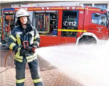  ?? FOTO: MARKUS JOOSTEN ?? Julian Siedenbied­el, Oberbrandm­eister bei der Weseler Feuerwehr, spritzt mit einem Schnellang­riffsschla­uch Wasser auf das Pflaster des Bahnhofs.
