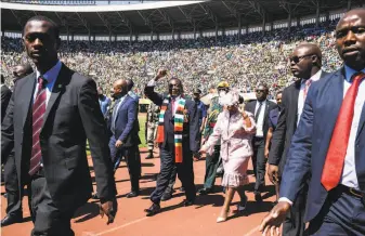  ?? Jekesai Njikizana / AFP / Getty Images ?? President Emmerson Mnangagwa (center) arrives to take his oath of office in the capital of Harare. The Constituti­onal Court has rejected opposition claims of vote-rigging in the election.