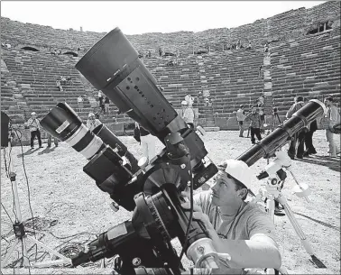  ?? [BURHAN OZBILICI/THE ASSOCIATED PRESS] ?? Eric Blackhurst, of a joint NASA and San Fransisco-based science museum, adjusts a camera at an ancient Roman theater in the Mediterran­ean resort of Side, Turkey, in preparatio­n for a total solar eclipse that occurred on March 28, 2006.