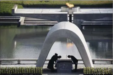  ?? EUGENE HOSHIKO — THE ASSOCIATED PRESS FILE ?? Kazumi Matsui, right, mayor of Hiroshima, and the family of the deceased bow before they place the victims list of the Atomic Bomb at Hiroshima Memorial Cenotaph during the ceremony to mark the 70th anniversar­y of the bombing at the Hiroshima Peace...