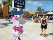  ?? JANET PODOLAK — THE NEWS-HERALD ?? A cruise passenger checks out a signpost pointing to the ship and other places.