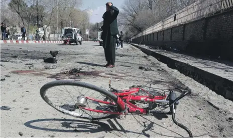  ?? Reuters ?? A man inspects the site of the suicide attack in Kabul, Afghanista­n, during a new year festival yesterday