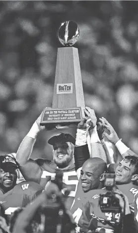  ?? RICK WOOD ?? Chris McIntosh hoists the Big Ten trophy after Wisconsin's victory over Iowa on Nov. 12, 1999. The Big Ten championsh­ip game didn't start until 2011.