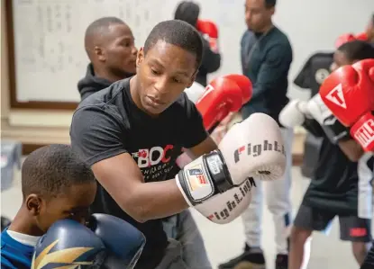  ?? BRIAN ERNST/SUN-TIMES ?? Jamyle Cannon, executive director and founder of The Bloc, works with students during an after-school boxing class at Frazier Preparator­y Academy.